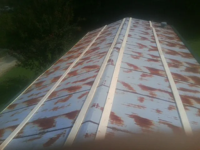 Rusted metal roof panels with new wood purlins before replacement — Storm Damage Roof Repair in Gretna by Roofing Brothers